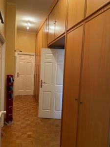 korytarz z drewnianymi szafkami i białymi drzwiami w obiekcie MAGGIE HOUSE w Rzymie