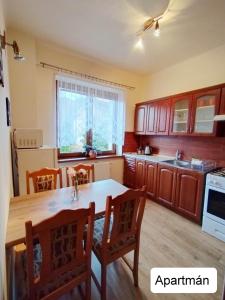 a kitchen with a wooden table and a dining room at Dům Tamara in Luhačovice