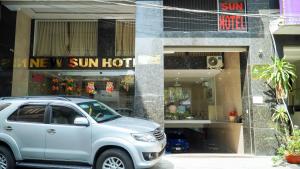 a silver suv parked in front of a store at New Sun Hotel Phu Nhuan in Ho Chi Minh City