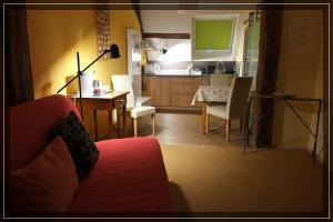 a living room with a couch and a table and a kitchen at Studio in der alten Scheune in Eschbach