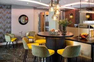 a dining room with yellow chairs and a table at Leonardo Boutique Hotel Krakow City Center in Krakow