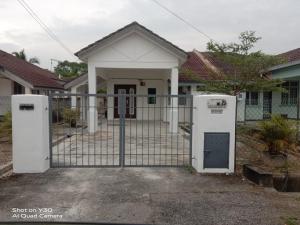 a gate with two refrigerators in front of a house at Imani Homestay Beach Gateway Bagan Lalang in Bagan Lalang