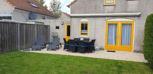 a patio with chairs and tables and a fence at Kustverhuur, Vakantiepark Fort Soleil 23 in Breskens