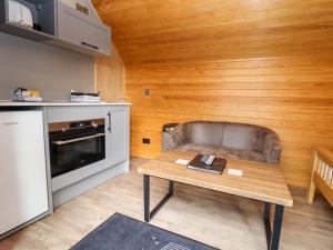 a small kitchen with a table and a couch at Willow Lodge At Bridge Lake Farm & Fishery in Banbury