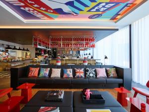 a living room with a couch and a bar at citizenM London Shoreditch in London