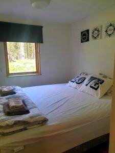 a bedroom with a white bed with a window at Sala Cabin in Sala