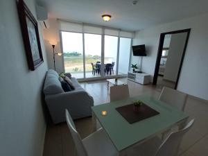 sala de estar con sofá, mesa y sillas en Playa Blanca Apartamentos, en Río Hato
