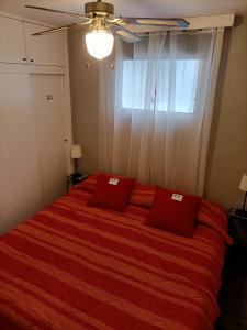 una camera da letto con un letto con lenzuola rosse e una finestra di Casa Bianca Wifi5G 56m2 DoubleRoom a Puerto de la Cruz