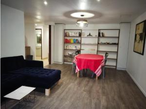 een woonkamer met een rode tafel en een bank bij Appartement aux Airelles in Embrun