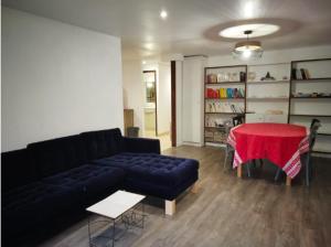 een woonkamer met een bank en een rode tafel bij Appartement aux Airelles in Embrun