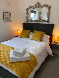 a bedroom with a large white bed with a mirror at Dog Friendly Stylish Modern Flat, near Beach in Newquay