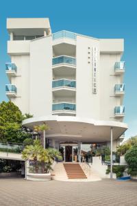 a white building with a staircase in front of it at Hotel Atlantico in Lido di Jesolo