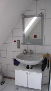 W łazience znajduje się umywalka i lustro. w obiekcie Winzeranwesen - Weingut Christian Eberley - Haupthaus I MINDESTAUFENTHALT 3 NÄCHTE - MINIMUM STAY 3 NIGHTS w mieście Neustadt an der Weinstraße