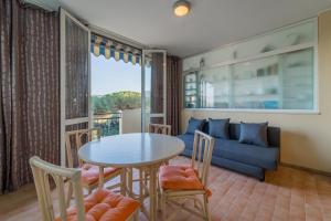 a living room with a table and chairs and a couch at Appartamenti Verde Blu in Capoliveri