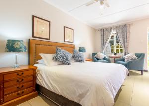 een slaapkamer met een bed met blauwe en witte kussens bij The Coach House in Franschhoek
