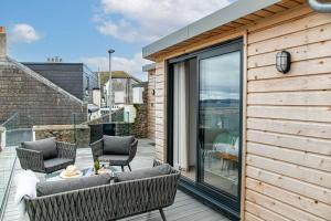 un patio con sillas y una mesa en una terraza en The Sail Loft, Maritime, en Brixham