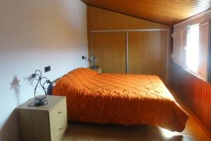 sypialnia z łóżkiem z pomarańczową narzutą w obiekcie CASA DO CRUCEIRO - RÍAS BAJAS w mieście Tomiño