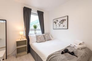 een kleine slaapkamer met een bed en een raam bij Modern Spacious 3 Bedroom City Centre Apartment - Free Parking - Private Balcony in Edinburgh