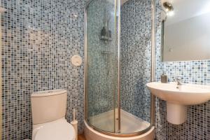 een badkamer met een douche, een toilet en een wastafel bij Modern Spacious 3 Bedroom City Centre Apartment - Free Parking - Private Balcony in Edinburgh