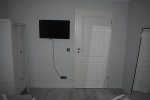 Ferienwohnung JaRa 1 في ستولبرغ: غرفة بيضاء مع تلفزيون بشاشة مسطحة على الحائط
