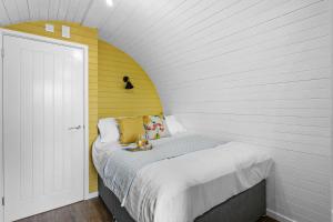 Dormitorio pequeño con cama con pared amarilla en Morgan Sweet, Apple Tree Glamping, Nr Wells en Wells