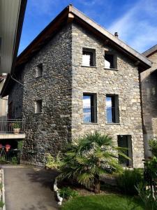 a brick building with a tree in front of it at Beau studio dans ancienne grange rénovée. in Blonay