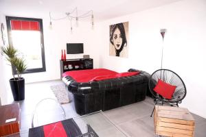 una camera da letto con un divano in pelle nera in una stanza di Beau studio dans ancienne grange rénovée. a Blonay