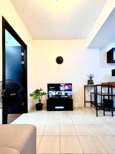 a living room with a flat screen tv on a wall at Mey’s Condo in Pasig - 1BR with Balcony in Manila