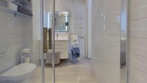 uma casa de banho com um WC, um lavatório e um espelho. em Le Pytheas Vieux Port Marseille em Marselha
