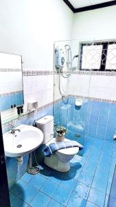 a blue tiled bathroom with a toilet and a sink at Loft Villa 1190 - Islamic Homestay in Melaka