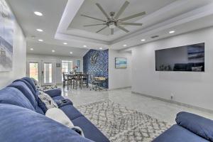 a living room with a blue couch and a tv at Patio and Grill Spacious Gem Near Gulf Coast! in Brownsville