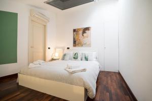a bedroom with a white bed with two towels on it at Corte Lotti Charming Loft in Pietrasanta