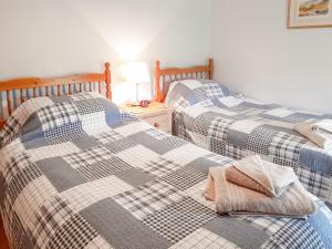 two beds sitting next to each other in a room at Greenrigg Cottage in Caldbeck