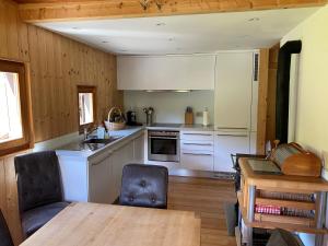 a kitchen with white cabinets and a wooden floor at Boutique Hotel Locanda Fior di Campo in Campo