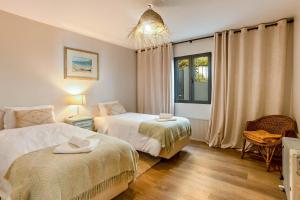 a bedroom with two beds and a window at Referta Apartamento T2 in Prazeres