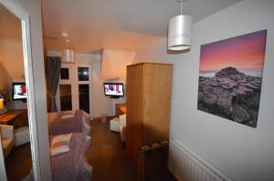 um quarto com uma sala de estar com um sofá e uma televisão em Crockatinney guest house em Ballintoy