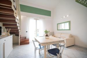 a kitchen and dining room with a wooden table and chairs at Corte Lotti Charming Loft in Pietrasanta