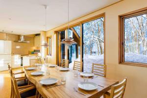 a dining room with a large wooden table with chairs at Sakura 88 - Luxury Villa - 280sqm 4 bedrooms in Hakuba