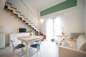 a living room with a table and a staircase at Corte Lotti Charming Loft in Pietrasanta