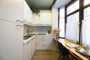 a kitchen with white cabinets and a wooden table at Cityhome Apartments in the heart of Antwerp in Antwerp