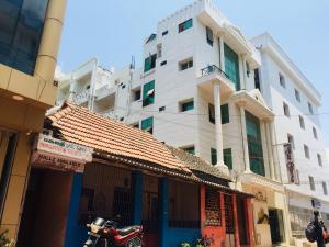 a motorcycle parked in front of a large building at Hotel Sun Rock in Kanyakumari