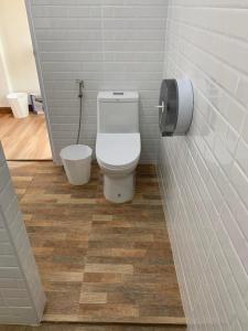 a bathroom with a toilet and a toilet paper dispenser at Hey Sunday Home in Ban Mit Mongkhon