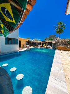 a swimming pool with blue water in a resort at Hotel Pousada Mahon Mar in Praia do Frances