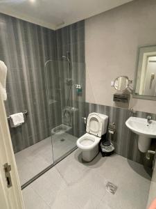 a bathroom with a shower and a toilet and a sink at The Y Hotel in Amman +37 photos