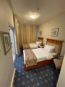 a hotel room with two beds and a window at The Y Hotel in Amman