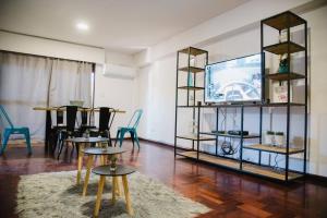 sala de estar con mesas y TV de pantalla plana en Avenida España Apartments. Pleno centro de Mendoza en Mendoza