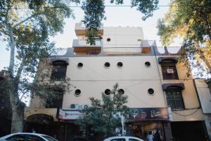 a white building with a balcony on top of it at Avenida España Apartments. Pleno centro de Mendoza in Mendoza