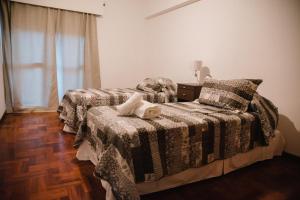 1 dormitorio con 2 camas y ventana en Avenida España Apartments. Pleno centro de Mendoza en Mendoza