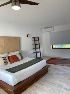 a bedroom with a large bed with a wooden headboard at Luana suites- Suite Koya in Zihuatanejo