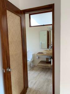 y baño con aseo y espejo. en Luana suites- Suite Koya en Zihuatanejo